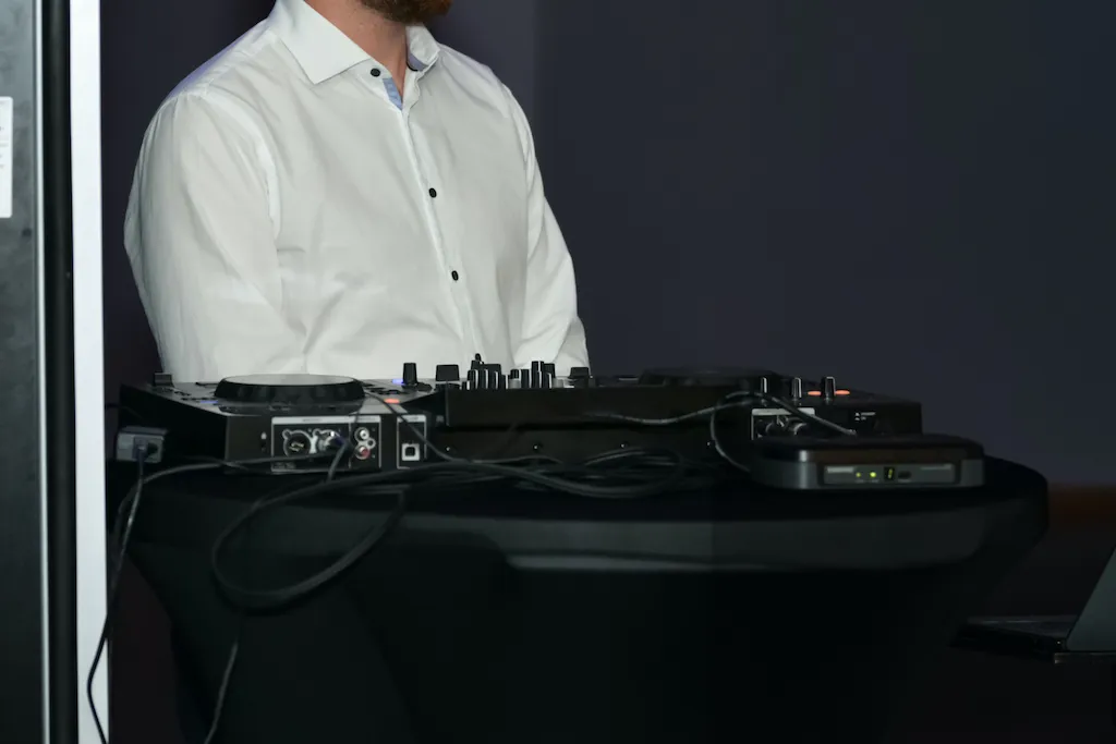 a-dj-in-a-white-shirt-and-his-equipment-at-a-wedding